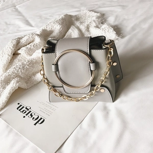 Minimalist matte leather crossbody bag with round gold handle and metal chain strap