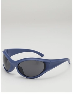 Macro side view of matte blue Y2K sports sunglasses with dark grey lenses and wide temples