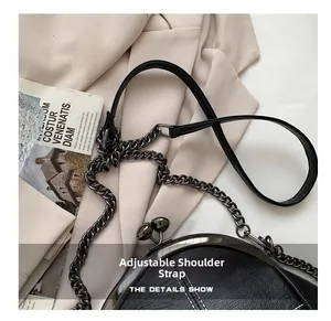 Detail of adjustable shoulder strap and hardware on black vintage leather shell bag