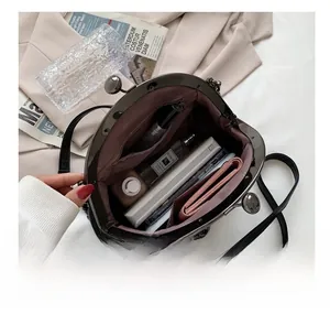 Interior view showing capacity of black leather crossbody bag with items inside