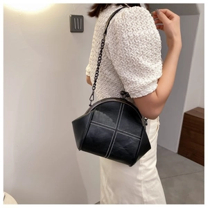 Cross-stitch black leather doctor bag with metal chain strap worn on person