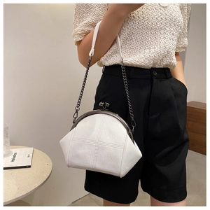 White leather shell bag with cross-stitch texture and vintage metal clasp on a model