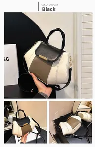 Detailed view of black tri-color Boston handbag with gold metal bar and fashion text