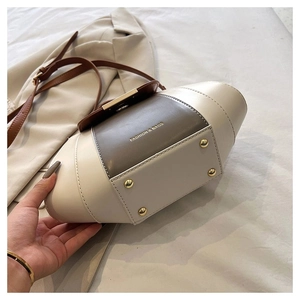 Detail view of the handbag base showing four gold anti-wear studs and tri-color design