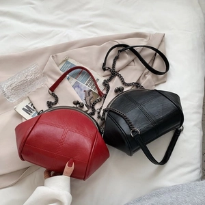 Close-up of vintage PU leather shell bags in red and black with chain straps