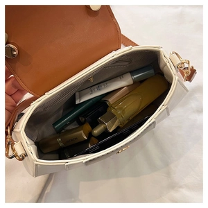 Internal view of cream minimalist handbag showing storage space for phone and makeup
