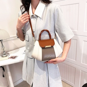 Detail of a three-color panel handbag with gold buckle and adjustable crossbody strap