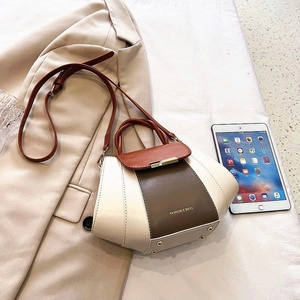 Detail of tricolor拼接 (cream, dark brown, reddish brown) handbag with gold bar lock