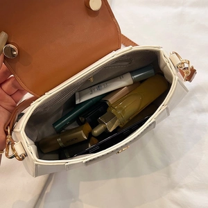Detailed interior of a two-tone leather crossbody bag showing spacious storage for cosmetics