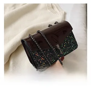 Détail du rabat en cuir verni marron foncé et paillettes colorées du sac bandoulière