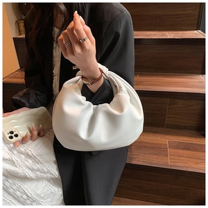 Close-up of white pleated cloud handbag with soft PU leather and rounded handle