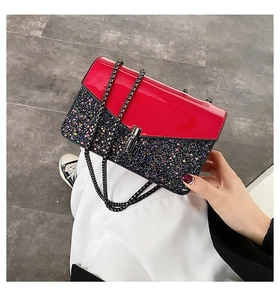 Détail de cuir verni rouge et paillettes noires avec chaîne en métal et fermoir rotatif