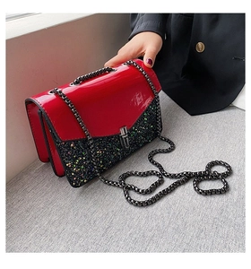 Détail du sac à chaîne en cuir verni rouge et paillettes noires avec fermoir rotatif