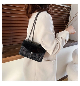 Sac à chaîne pailleté noir pour femme porté par un mannequin dans un cadre de vie naturel