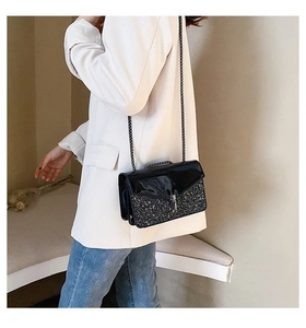 Détail du sac bandoulière en cuir verni noir et paillettes avec chaîne argentée