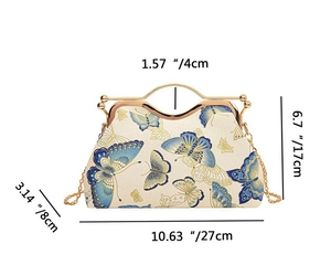Detailed view of vintage cream clutch bag with blue butterfly print and metal handles