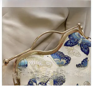 Detail of blue butterfly embroidery on jacquard fabric with golden metal handle