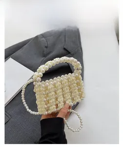 Detail der cremefarbenen Perlenhandtasche mit 3D-Rosenmuster und elegantem Perlengriff