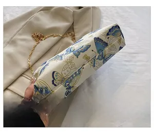 Close-up of bag bottom showing elegant blue butterfly print and gold chain strap