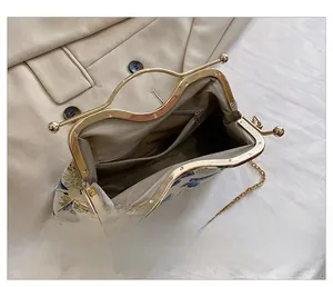 Detailed interior view of a vintage butterfly print handbag with golden metal frame