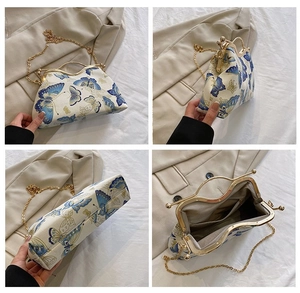 Detail view of vintage butterfly print kiss-lock handbag with gold metal frame and chain