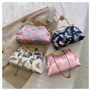 Close-up of vintage brocade pattern clutch bags with gold metal clasps and chain straps