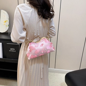 Detail of pink satin shoulder bag with 3D floral embroidery and gold metal handle