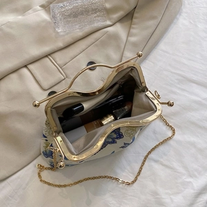 Internal view of floral clasp bag showing grey herringbone lining and cosmetic storage