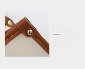 Vue détaillée de la couture en cuir beige et du rivet métallique sphérique doré