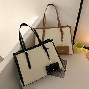 Détail de sacs fourre-tout avec surpiqûres contrastées, bandoulières et mini pochettes assorties