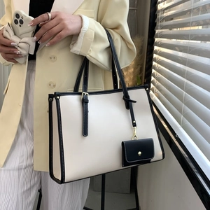 Détail du grand sac cabas crème avec bordure noire et pochette assortie attachée