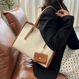 Détail du sac cabas crème et marron avec sangles réglables et porte-monnaie suspendu