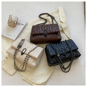 Détail de la texture matelassée en V et chaîne en métal sur ces sacs bandoulière chics