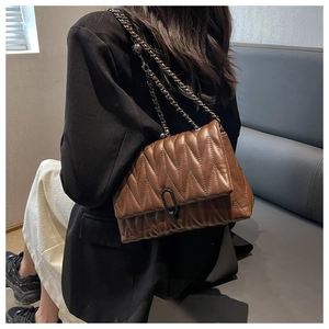 Détail du sac à bandoulière matelassé marron foncé avec chaîne et fermoir en métal