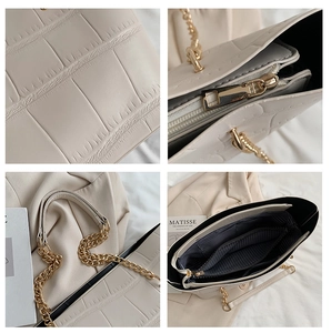 Detailed views of cream tote bag featuring croc texture, gold hardware and striped lining