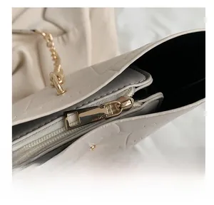 Detail shot of smooth gold-tone zipper and crocodile embossed faux leather tote bag