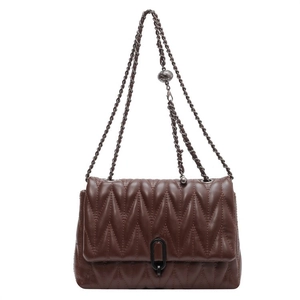 Sac bandoulière marron matelassé avec chaîne en métal et boucle de réglage à bille sur fond blanc