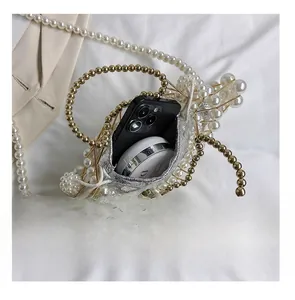 Detail view of the handmade pearl evening bag showing its capacity for a phone and makeup