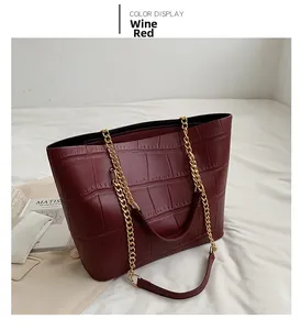 Detailed view of wine red crocodile texture tote bag with golden metal chain strap