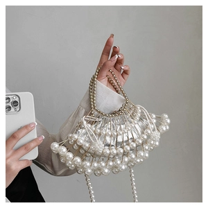 Close-up of fan-shaped silver evening bag with white pearls and beaded strap detail