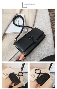 Détail du sac bandoulière noir avec bandoulière tissée et détails métalliques dorés