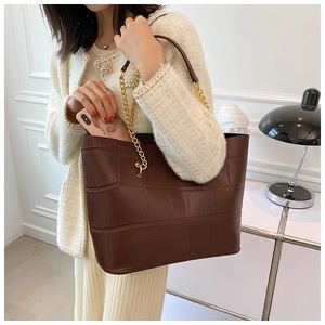 Detail of dark brown faux crocodile tote bag with gold chain strap and spacious interior