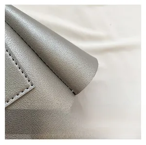 Détail du cuir métallisé argenté de haute qualité avec grain litchi et coutures précises