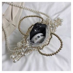 Detailed top view of handmade pearl cage bag showing capacity with phone and cosmetics
