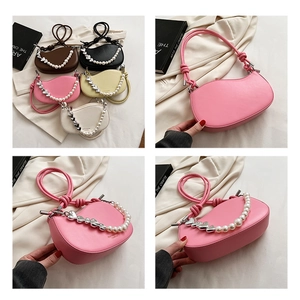 Detail of trendy crescent bag with colorful pearls and silver heart decorative chain