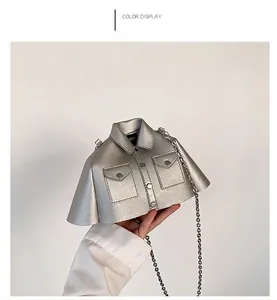 Détail du sac à main argenté en forme de chemise avec rivets, col et bandoulière chaîne
