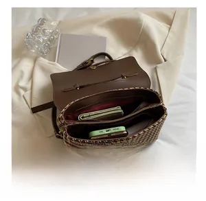 Detail view of plaid crossbody bag interior with compartments holding a phone and wallet