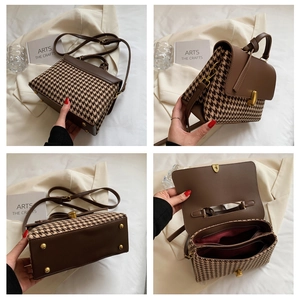 Detail view of houndstooth plaid handbag with brown leather trim and metal feet
