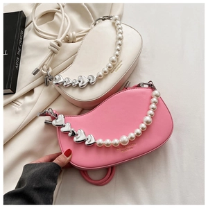 Detail of crossbody bag with decorative oversized pearl and heart-shaped chain strap