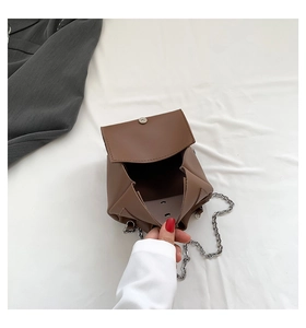 Vue détaillée de l'intérieur d'un sac à rabat en similicuir marron avec chaîne et fermoir magnétique